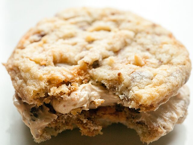 These chewy cookies are full of Butterfingers and stuffed with peanut butter buttercream; it's basically salty-sweet perfection | www.spachethespatula.com #recipe