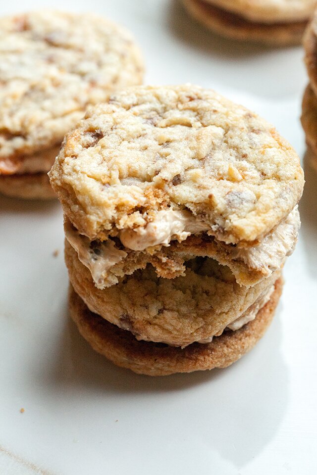 These chewy cookies are full of Butterfingers and stuffed with peanut butter buttercream; it's basically salty-sweet perfection | www.spachethespatula.com #recipe