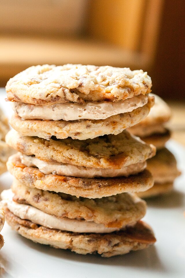 These chewy cookies are full of Butterfingers and stuffed with peanut butter buttercream; it's basically salty-sweet perfection | www.spachethespatula.com #recipe
