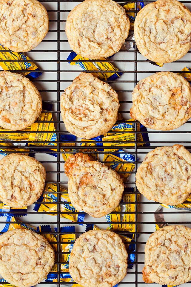These chewy cookies are full of Butterfingers and stuffed with peanut butter buttercream; it's basically salty-sweet perfection | www.spachethespatula.com #recipe