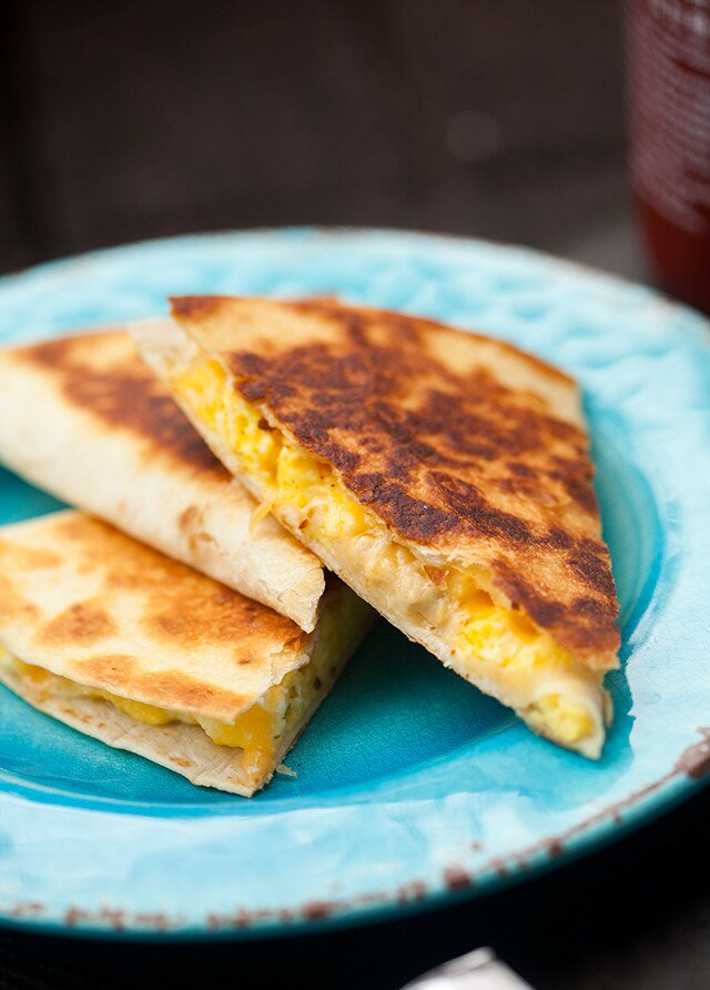 Creamy, cheesy scrambled eggs stuffed inside a crisp, golden brown tortilla! | www.spachethespatula.com #recipe