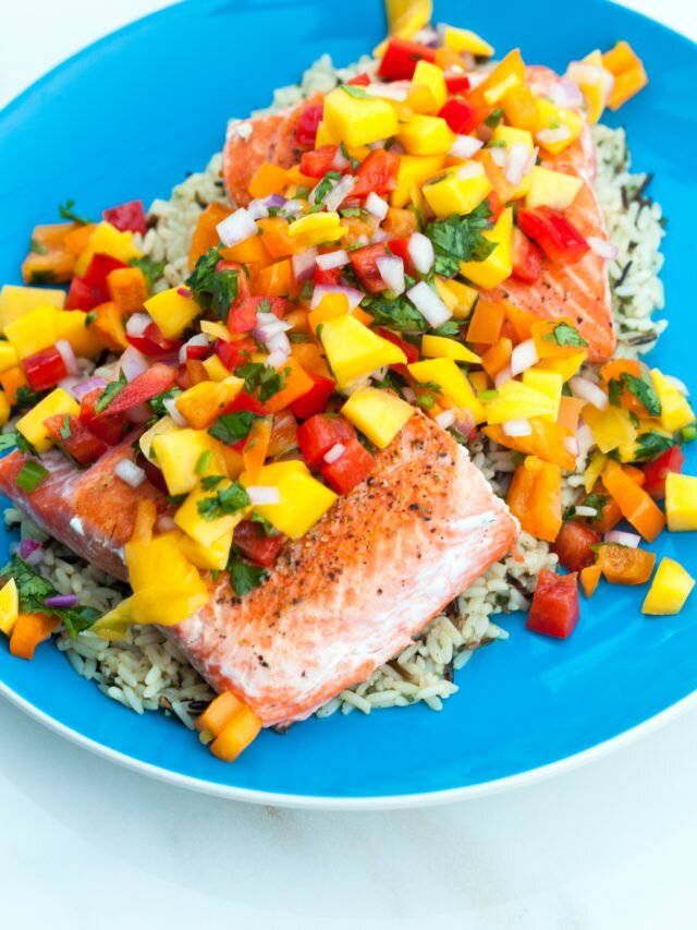A fresh and vibrant mango salsa tops seared salmon fillets in the perfect Summer dish! | www.spachethespatula.com #recipe